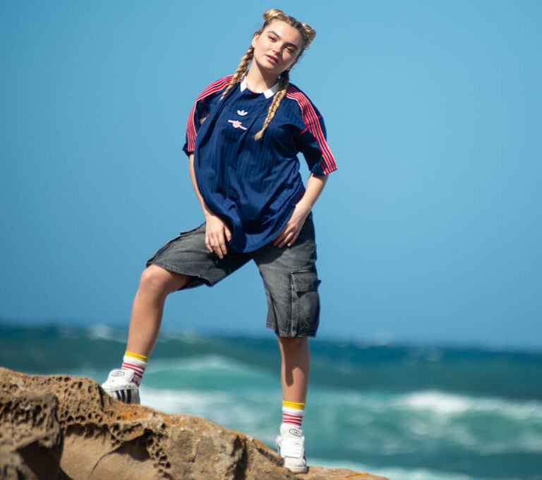 Ragazza vestita casual in posa su uno scoglio