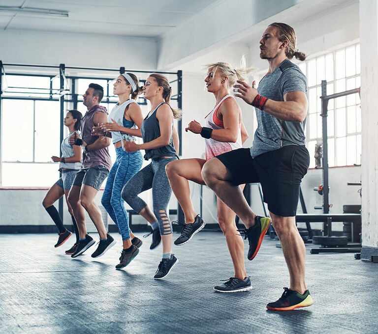 Gruppo di persone che fanno riscaldamento in palestra
