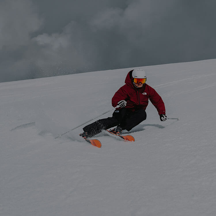 Ragazzo che fa slalom mentre che sci in montagna