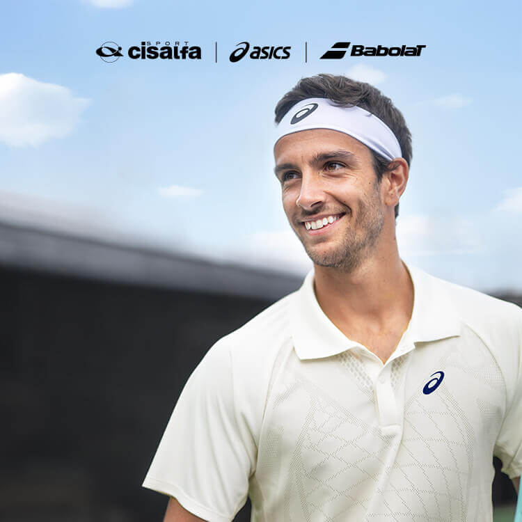 Ragazzo che gioca a tennis con scarpe e abbigliamento Asics