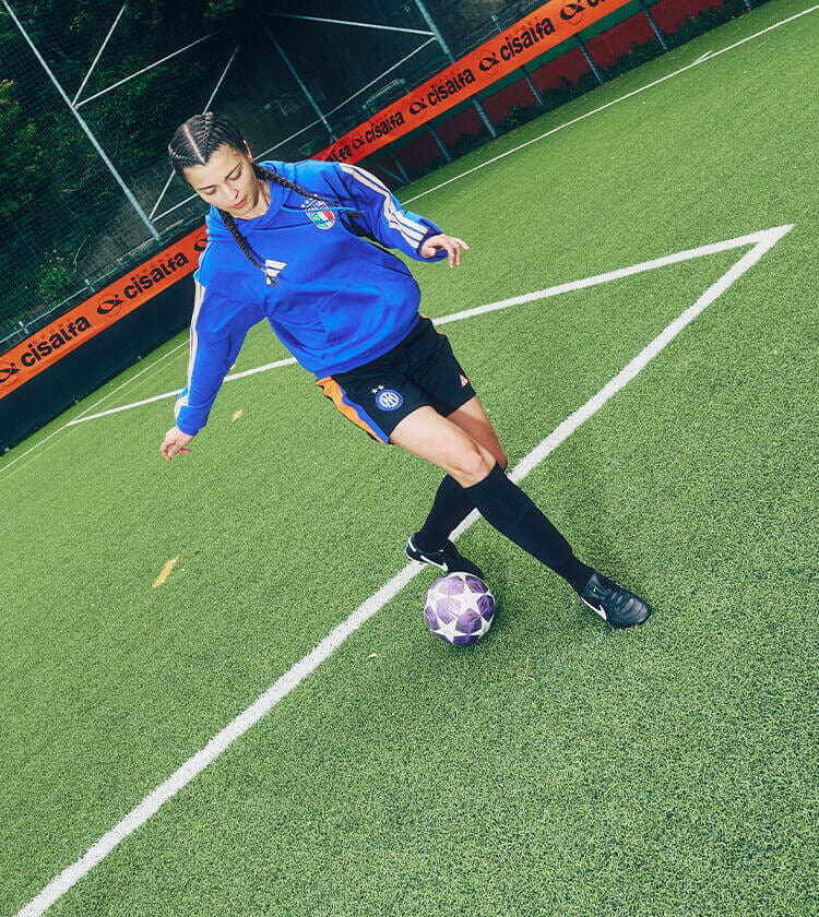 Ragazza che si allena in campo da calcio