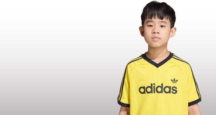 Bambino che indossa t-shirt adidas gialla e nera sportiva