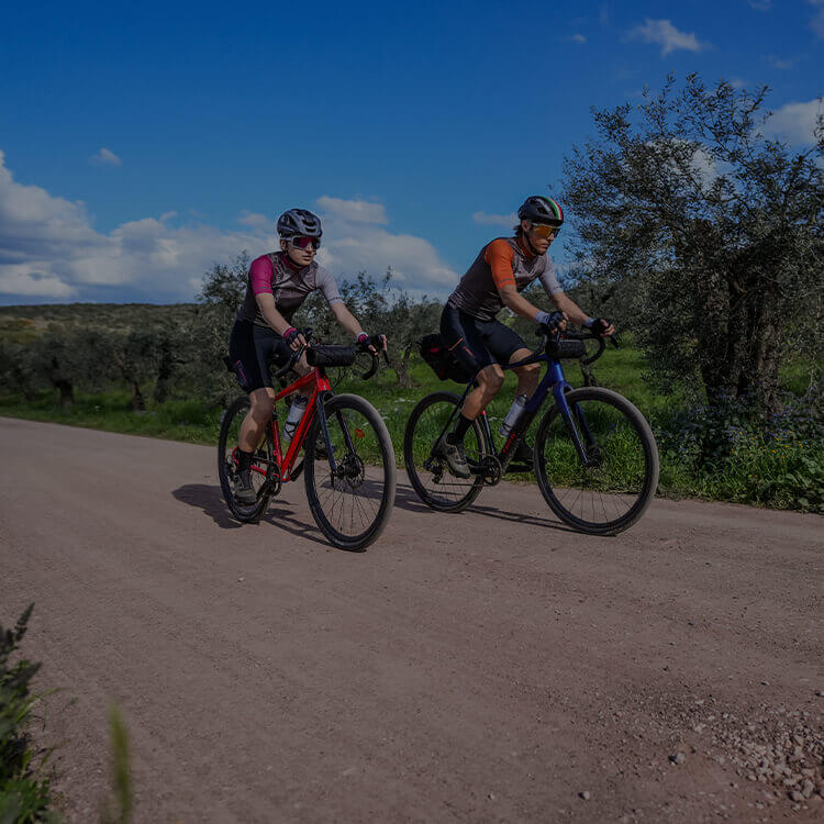 Due persone in campagna che vanno su bici da gravel